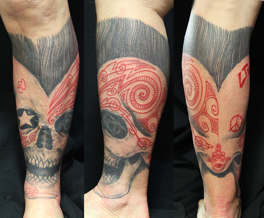 La suite du moko tatoué en rouge sur le côté supérieur gauche du mollet-skull